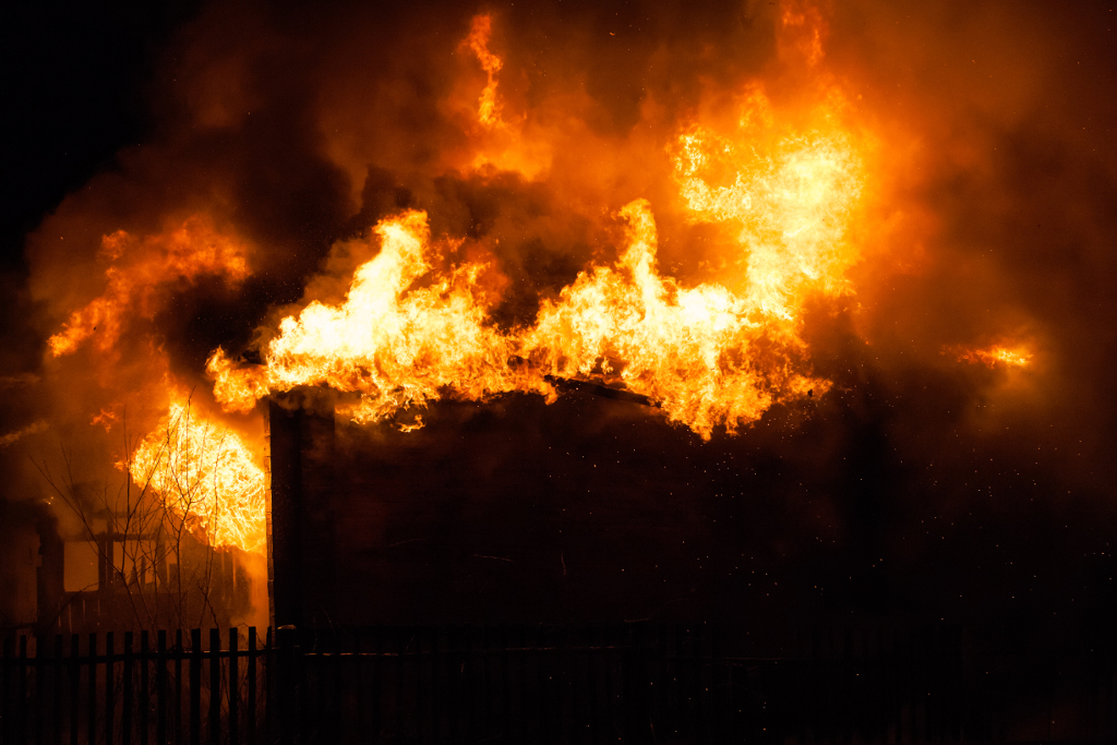 Brandend huis en brandende vingers